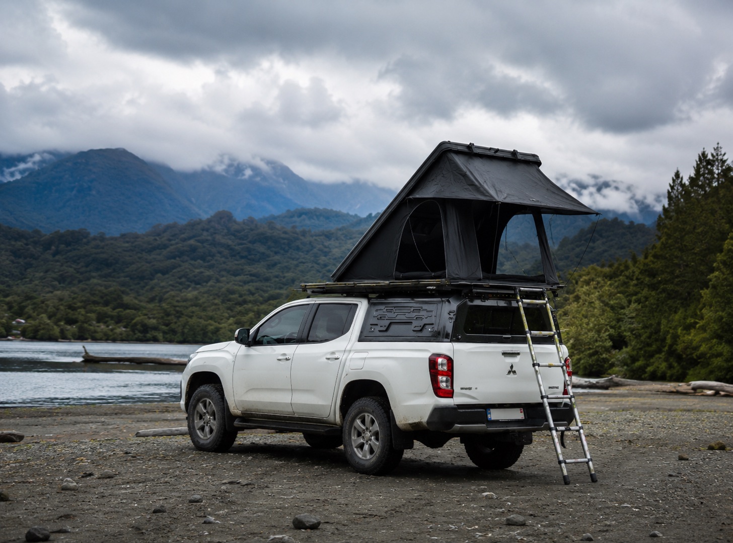 Carpa de techo ALTONIDO abierta sobre pickup frente a un lago del sur de Chile con montañas nubladas